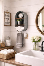 Load image into Gallery viewer, A rustic gray metal wall-mounted shelf with a clock, small plant, basket, and hanging towel, installed in a white shiplap bathroom wall above a sink.